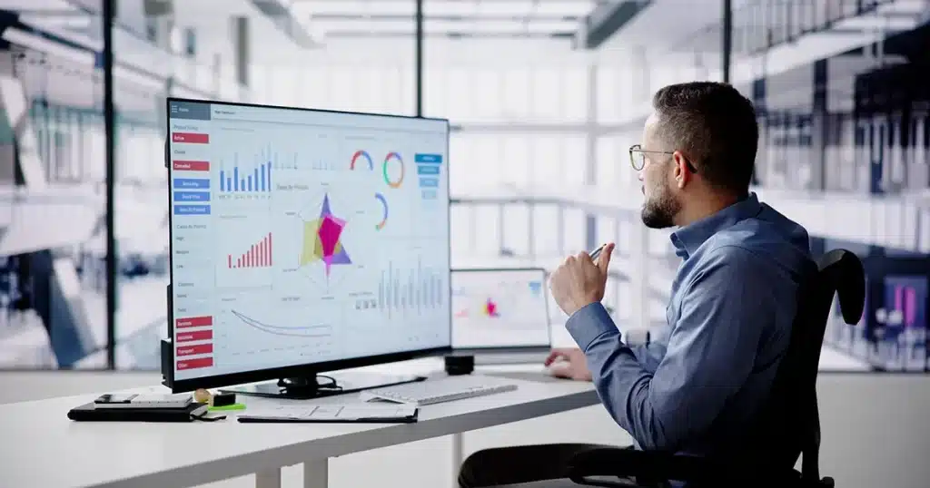 British business team analyzing UK AI adoption rate statistics on a visual digital dashboard in a London office.