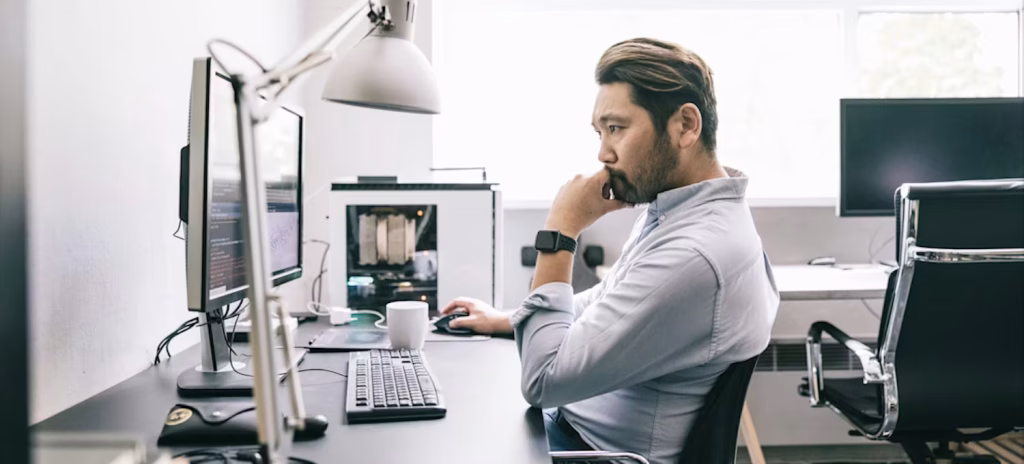 A UK professional working in a modern office using artificial intelligence software on a laptop. will ai replace my job uk